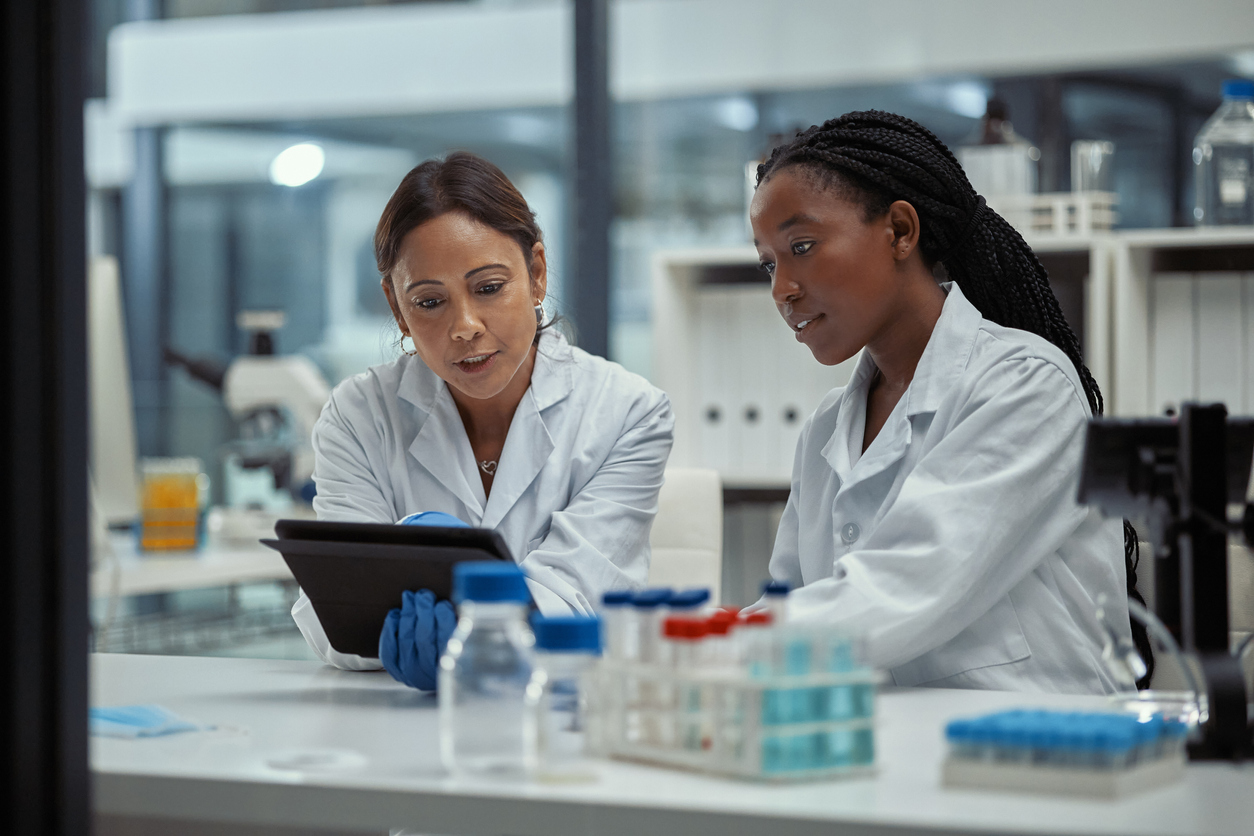 Two Scientists in Lab Coats Looking at a Computer Screen